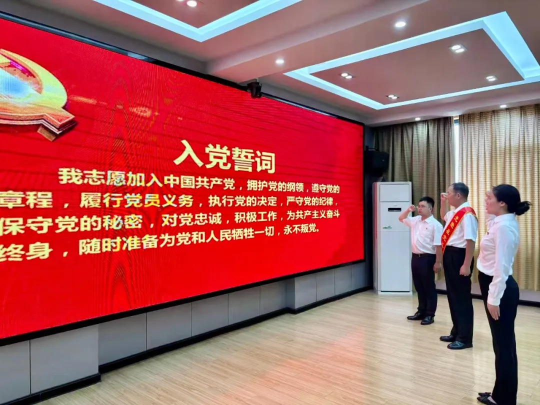 在漆永华同志的带领下，7月即将转正的预备党员张明莉同志面向党旗，高举右拳，庄严宣誓.jpg